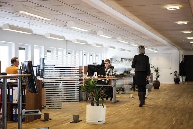 Das Büro eines kleinen Betriebs: Ordner und Papierstapel auf dem Schreibtisch, daneben ein älterer PC.